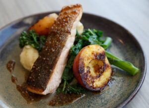 FLAVOURS: The crispy skinned maple-glazed salmon with grilled peaches.